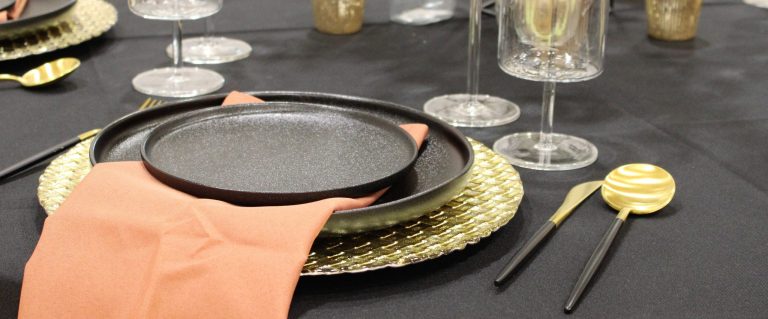 Elegant outdoor evening event with string lights, clear-top tent, and guests gathered around a poolside fire pit